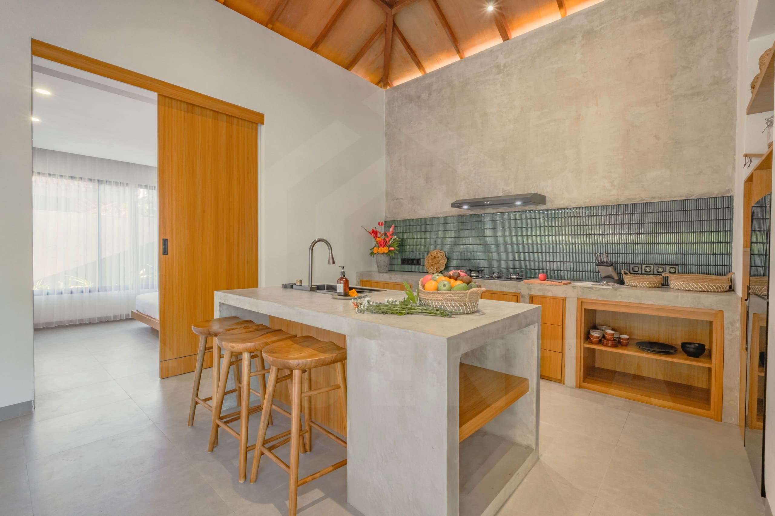 Minimalist kitchen island in Ubud leasehold villa with wooden cabinetry