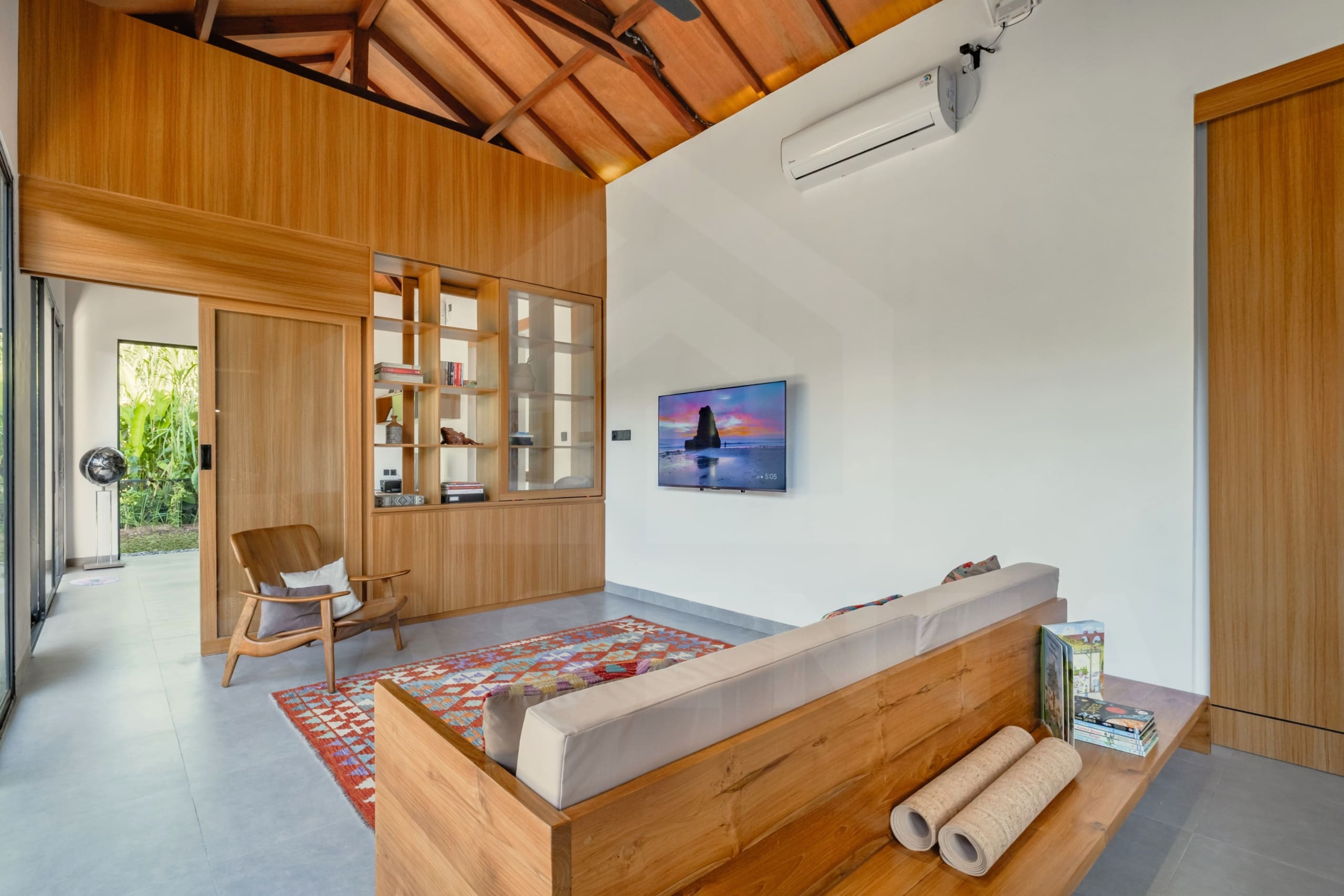 Cozy living area in Ubud villa with vaulted wood ceiling and entertainment nook