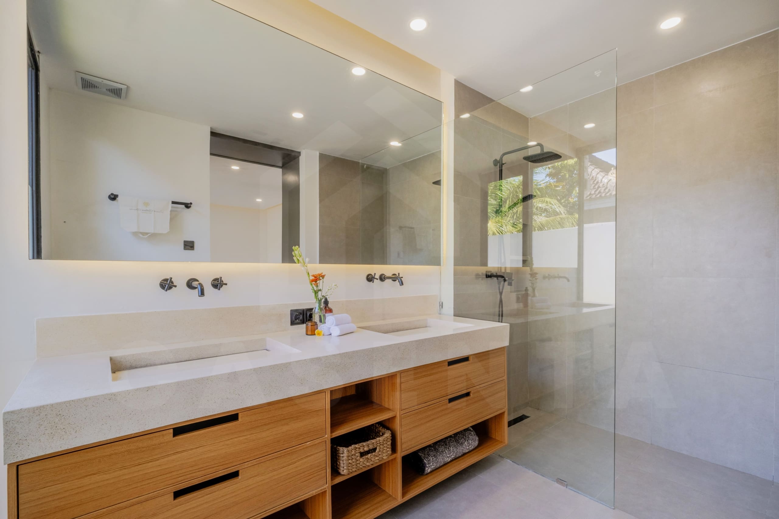 Spacious dual-vanity bathroom with glass rain shower in Ubud villa
