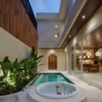 Private outdoor area with jacuzzi, plunge pool, and tropical plants in a modern Bali villa