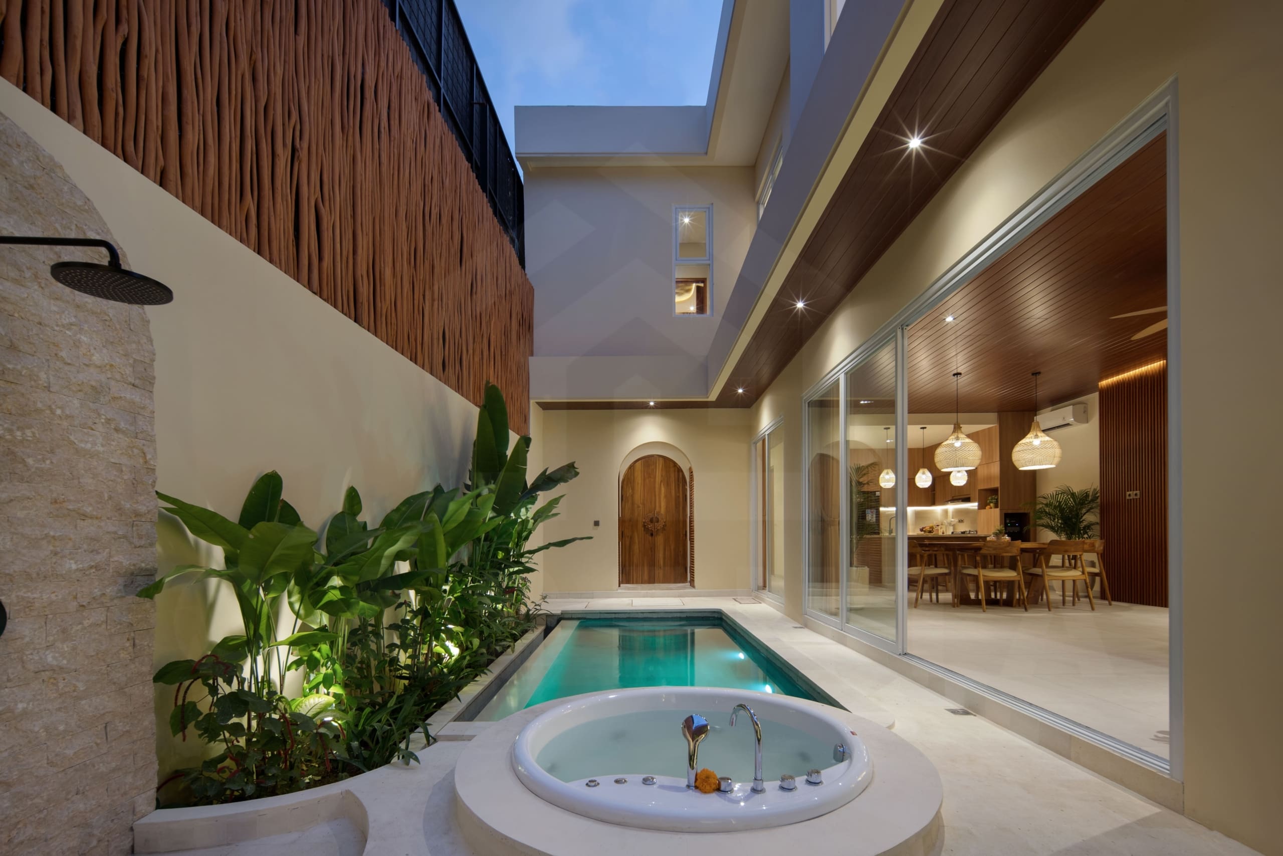 Private outdoor area with jacuzzi, plunge pool, and tropical plants in a modern Bali villa