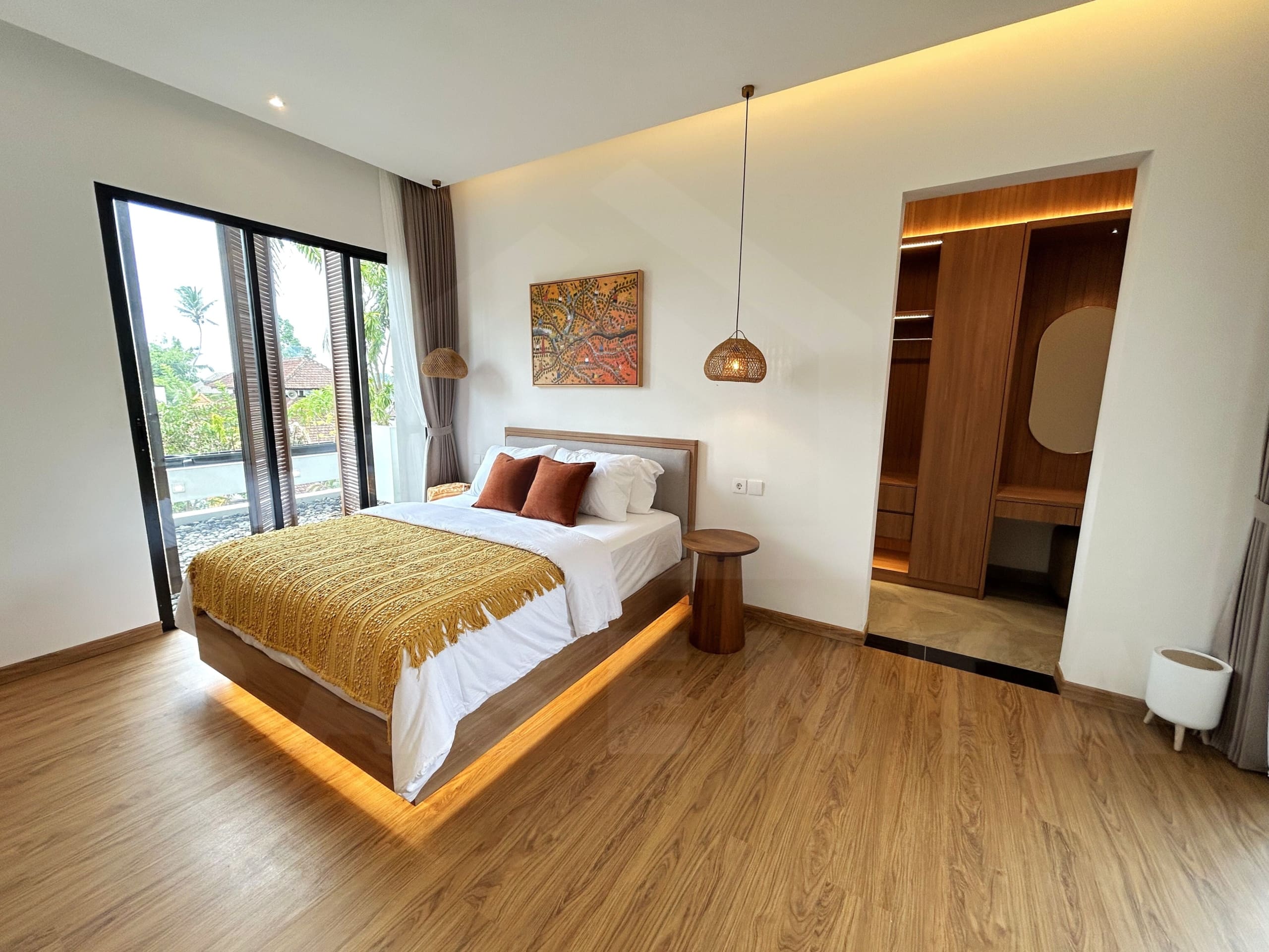 Spacious villa bedroom with balcony doors, warm lighting, and walk-in wardrobe.