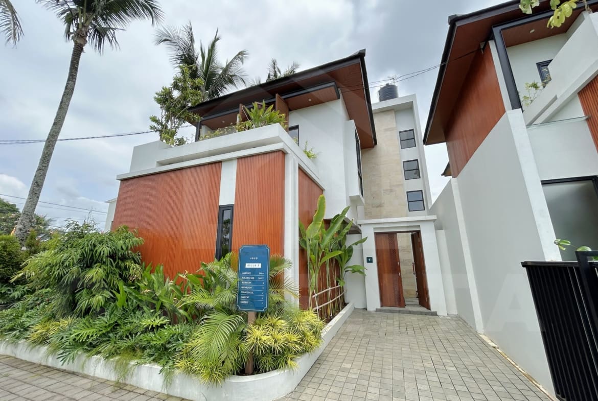 Contemporary villa exterior with wood paneling, tropical landscaping, and private entrance.