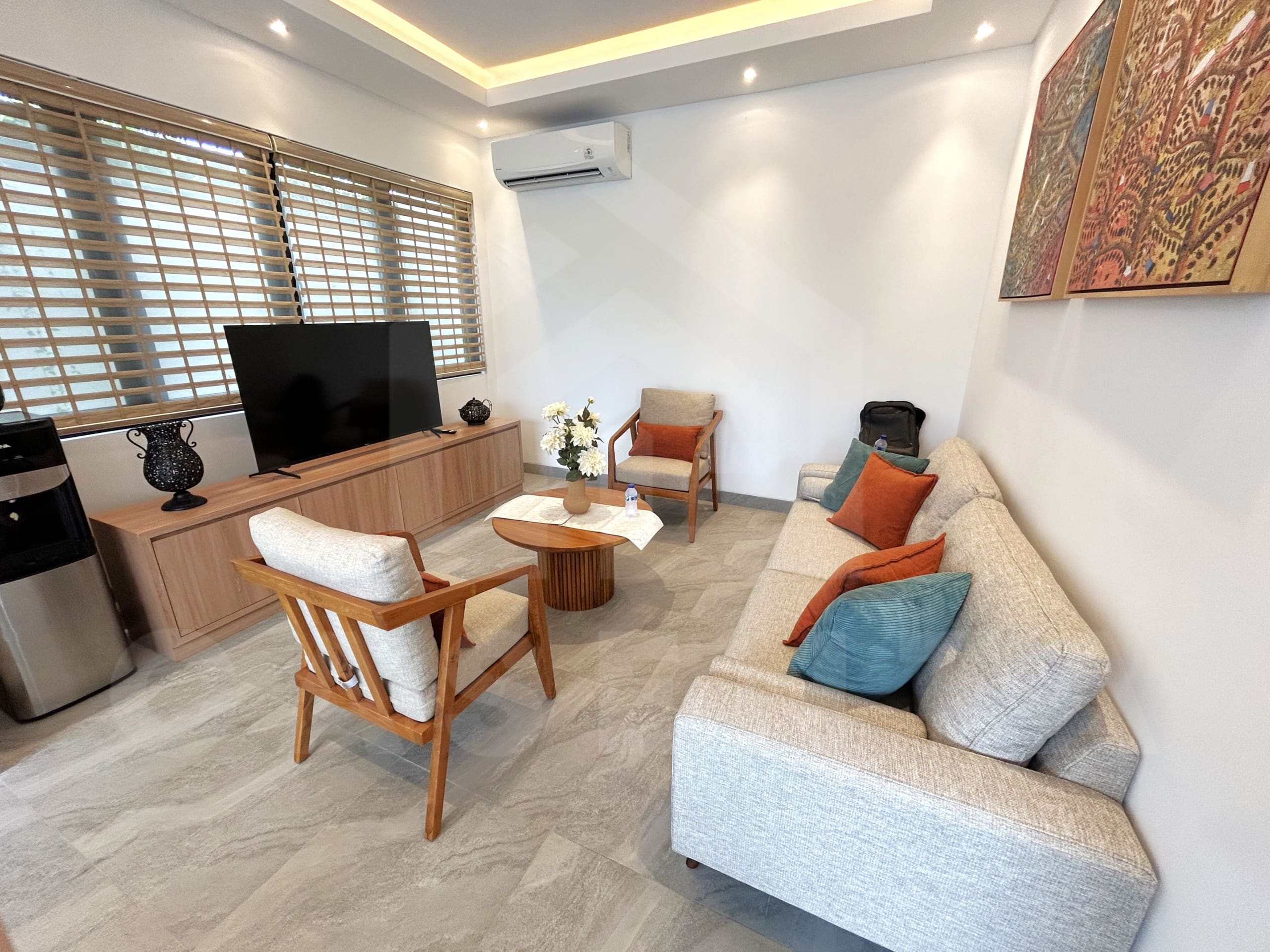 Cozy villa living room with neutral sofa, wood furniture, and large TV console.