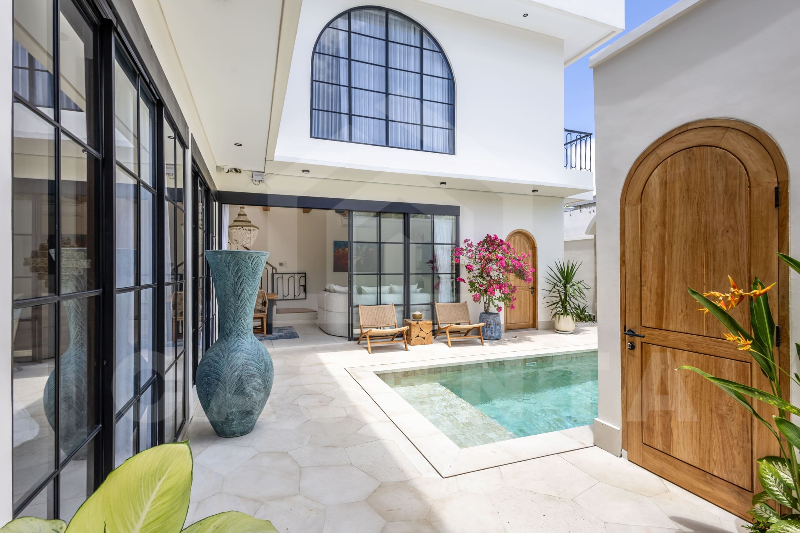 Balangan villa outdoor pool and seating area with arched windows