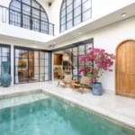 Balangan villa outdoor lounge with rattan chairs and flowering plants by the pool