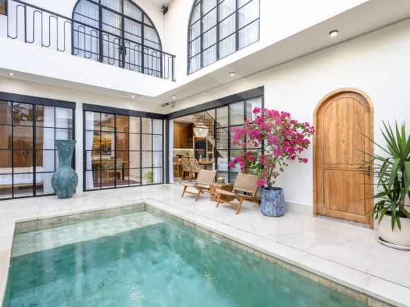 Balangan villa outdoor lounge with rattan chairs and flowering plants by the pool