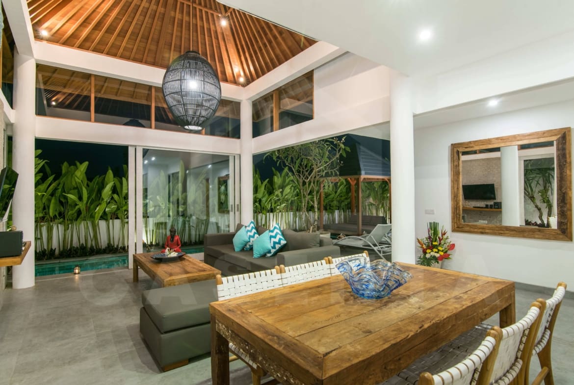 Living area of leasehold villa Berawa at night with pool view and modern furnishings