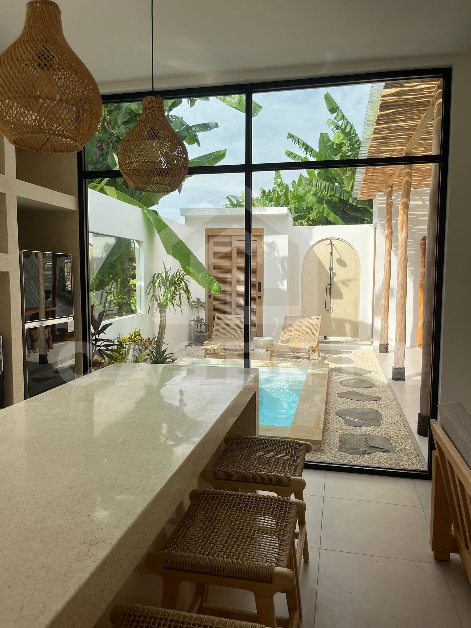 Modern tropical villa open kitchen overlooking private pool and outdoor shower