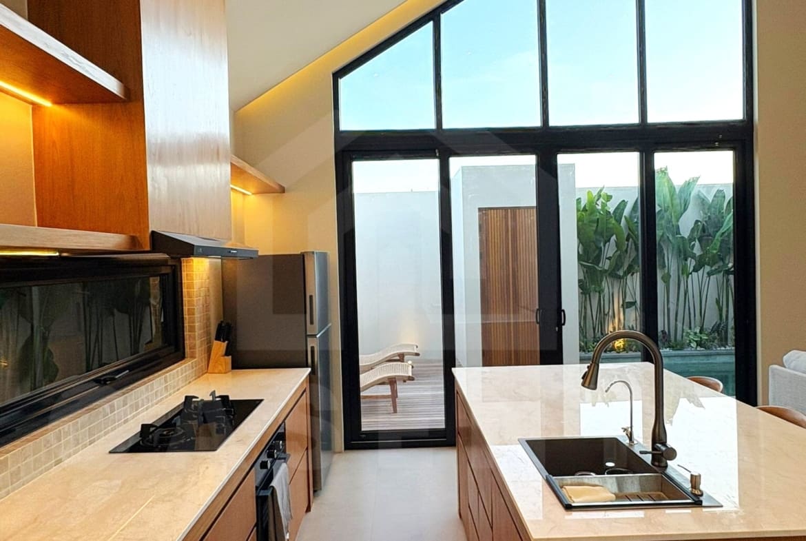 Fully equipped kitchen and dining island in Tumbak Bayuh villa
