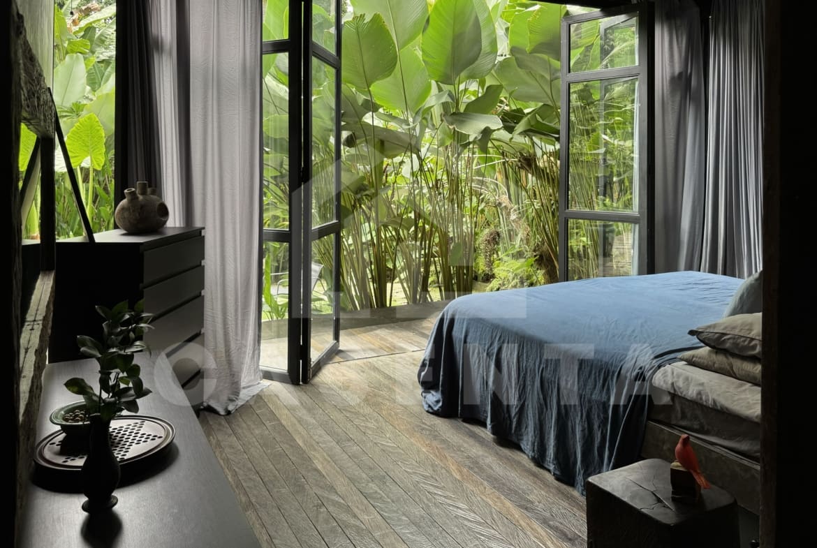 Master bedroom in Ubud villa with jungle view and large glass doors