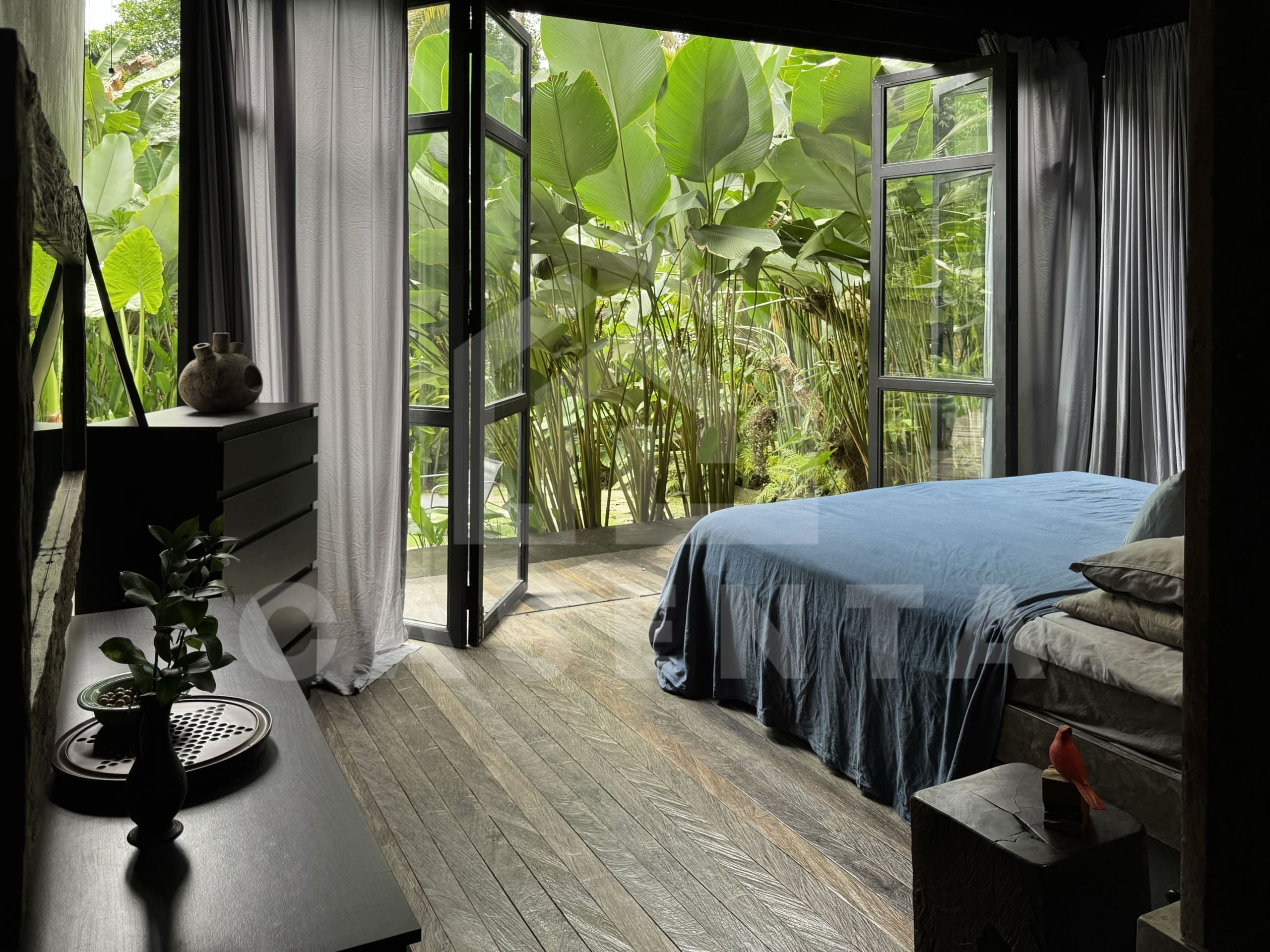 Master bedroom in Ubud villa with jungle view and large glass doors