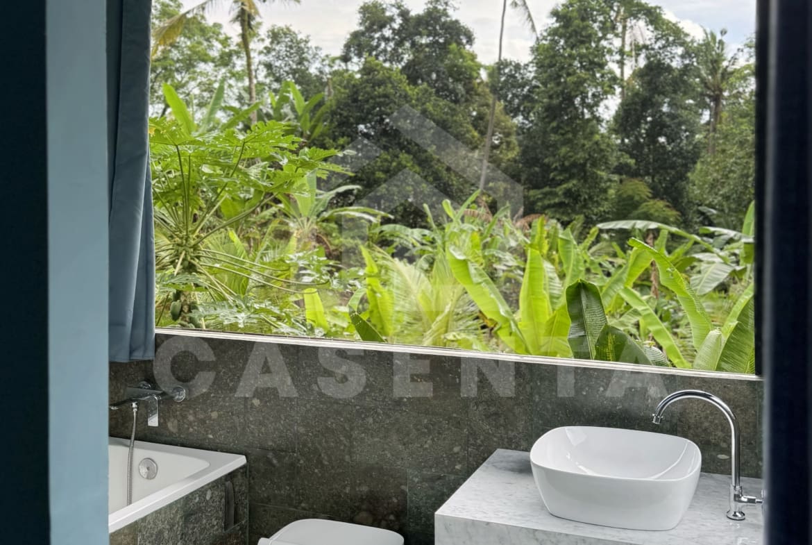 Ensuite bathroom in Ubud villa with marble vanity and jungle view window