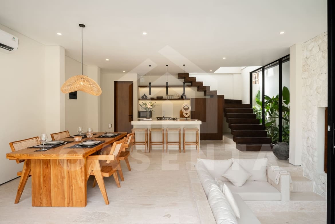 Open plan living and dining area in batu bolong villa with staircase feature