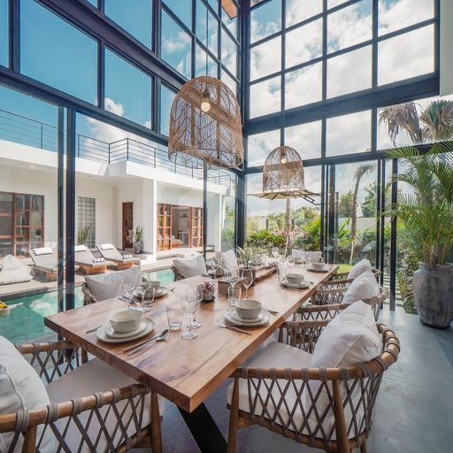 Double-height dining area overlooking pool in cemagi villa