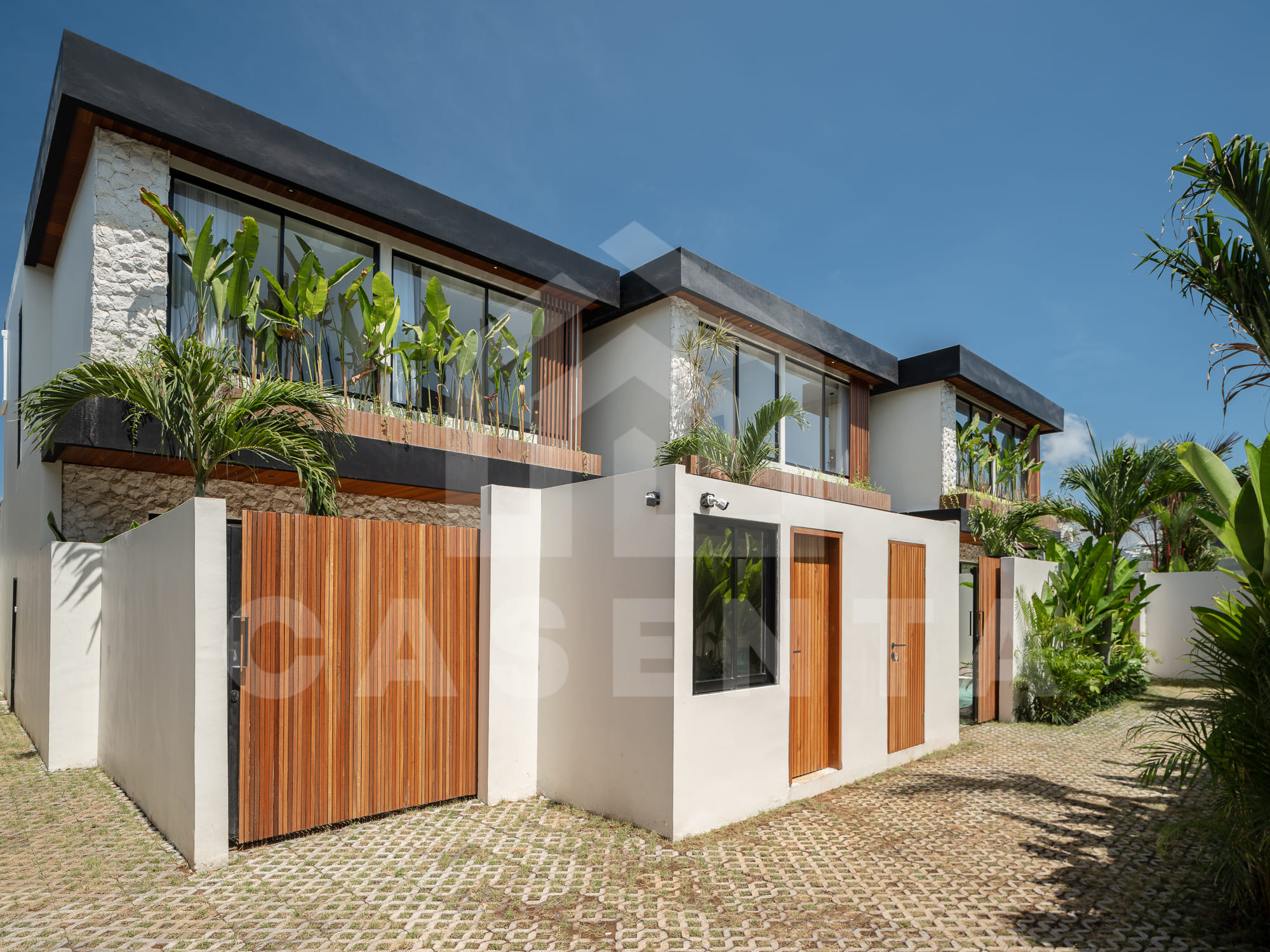Contemporary tropical facade of batu bolong villa with wood and stone accents