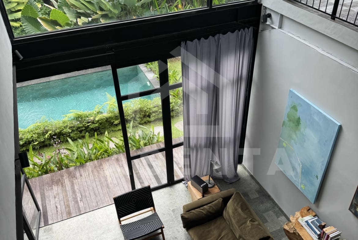 Double-height living area in Ubud villa overlooking pool