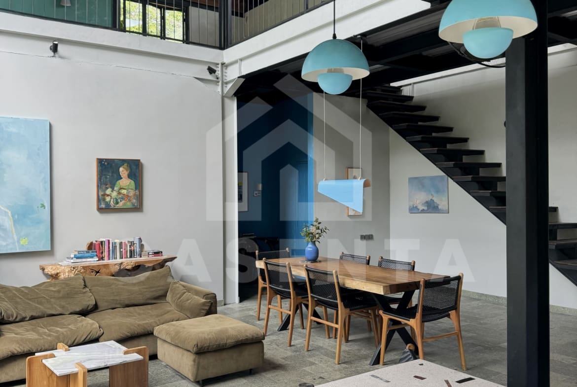 Open-plan kitchen and dining area in Ubud villa with high ceiling