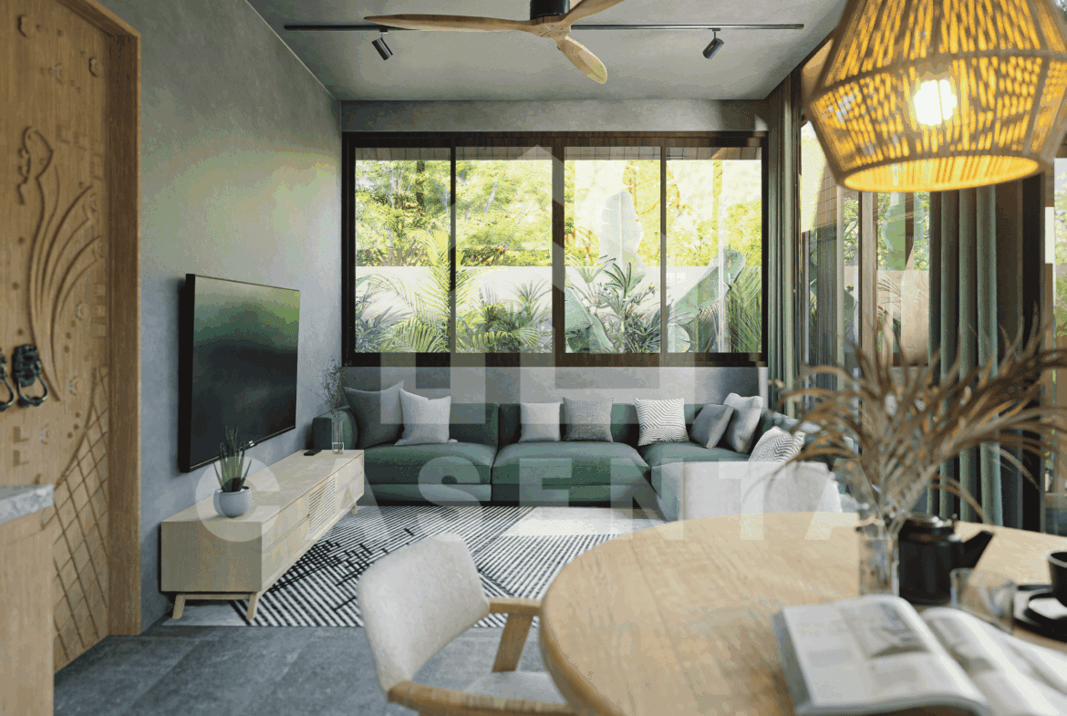 Living area in Ubud leasehold villa with large windows, green sofa, and indoor-outdoor garden views