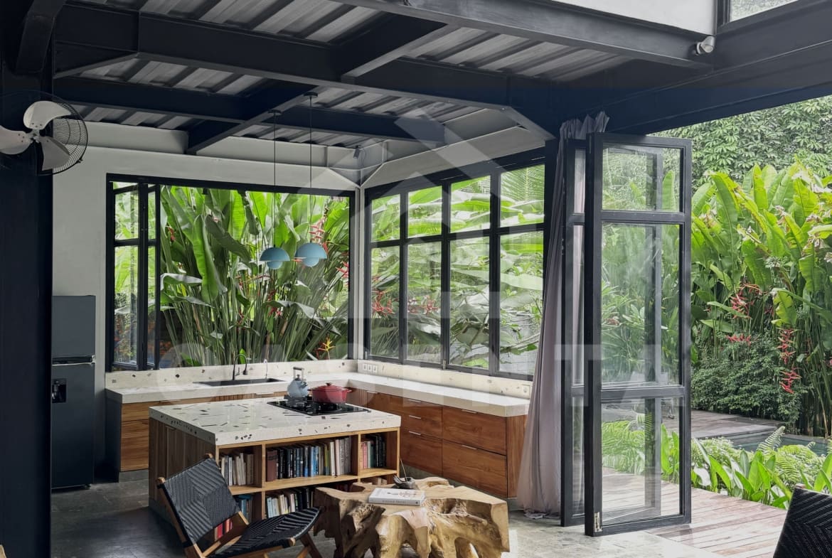 Modern kitchen with island in Ubud villa surrounded by greenery