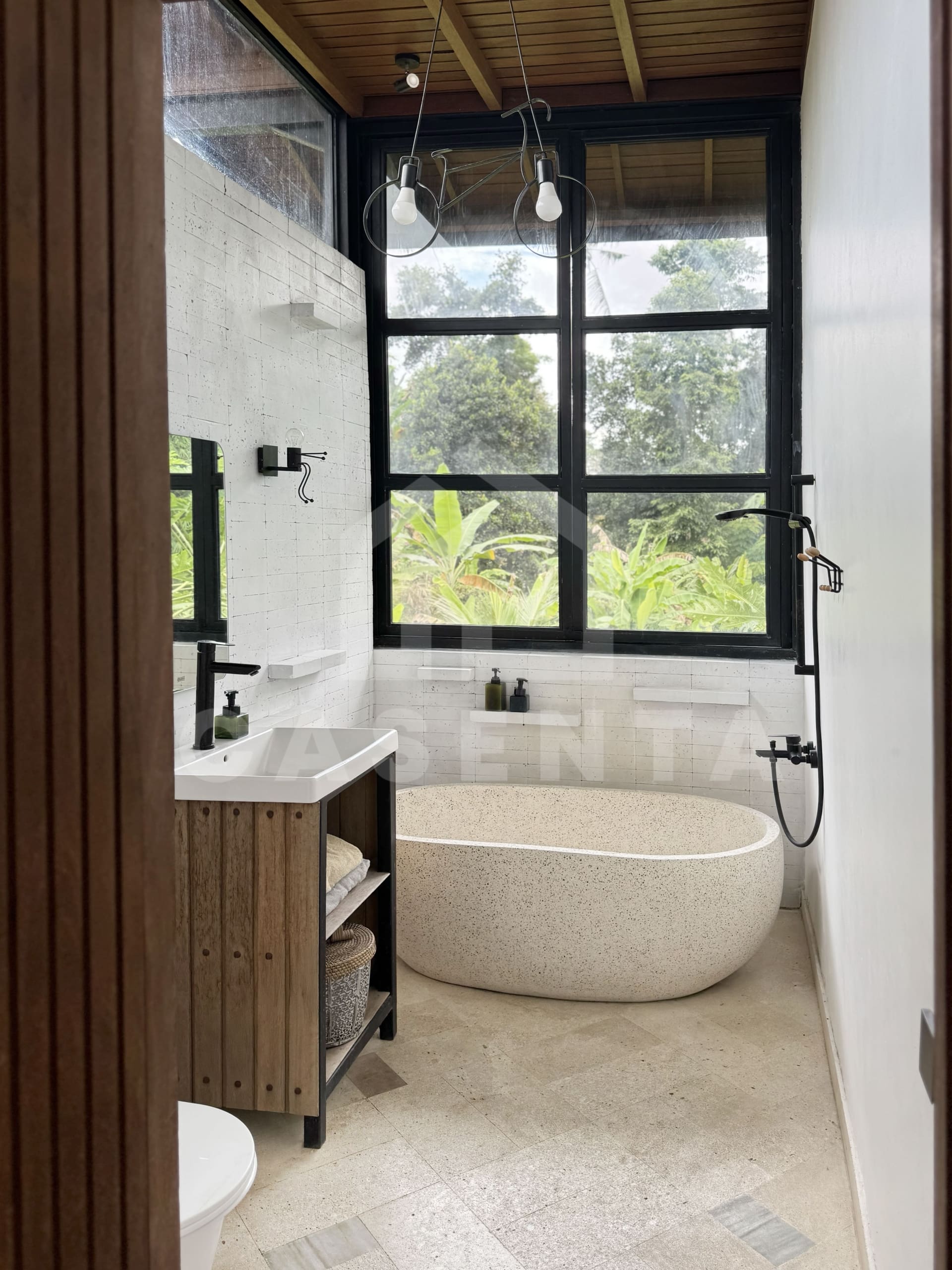 Freestanding bathtub in Ubud villa bathroom with large window