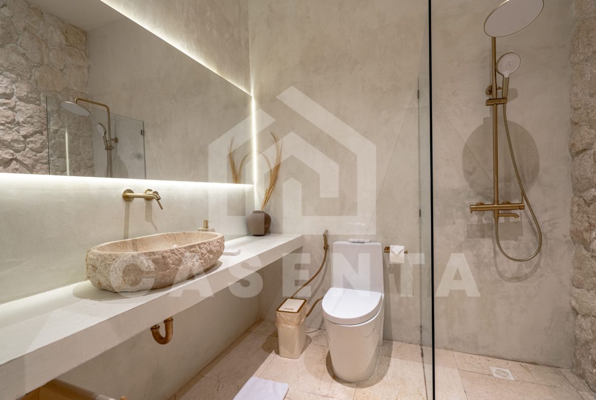 Modern bathroom in Sanur apartment with stone sink and walk-in shower