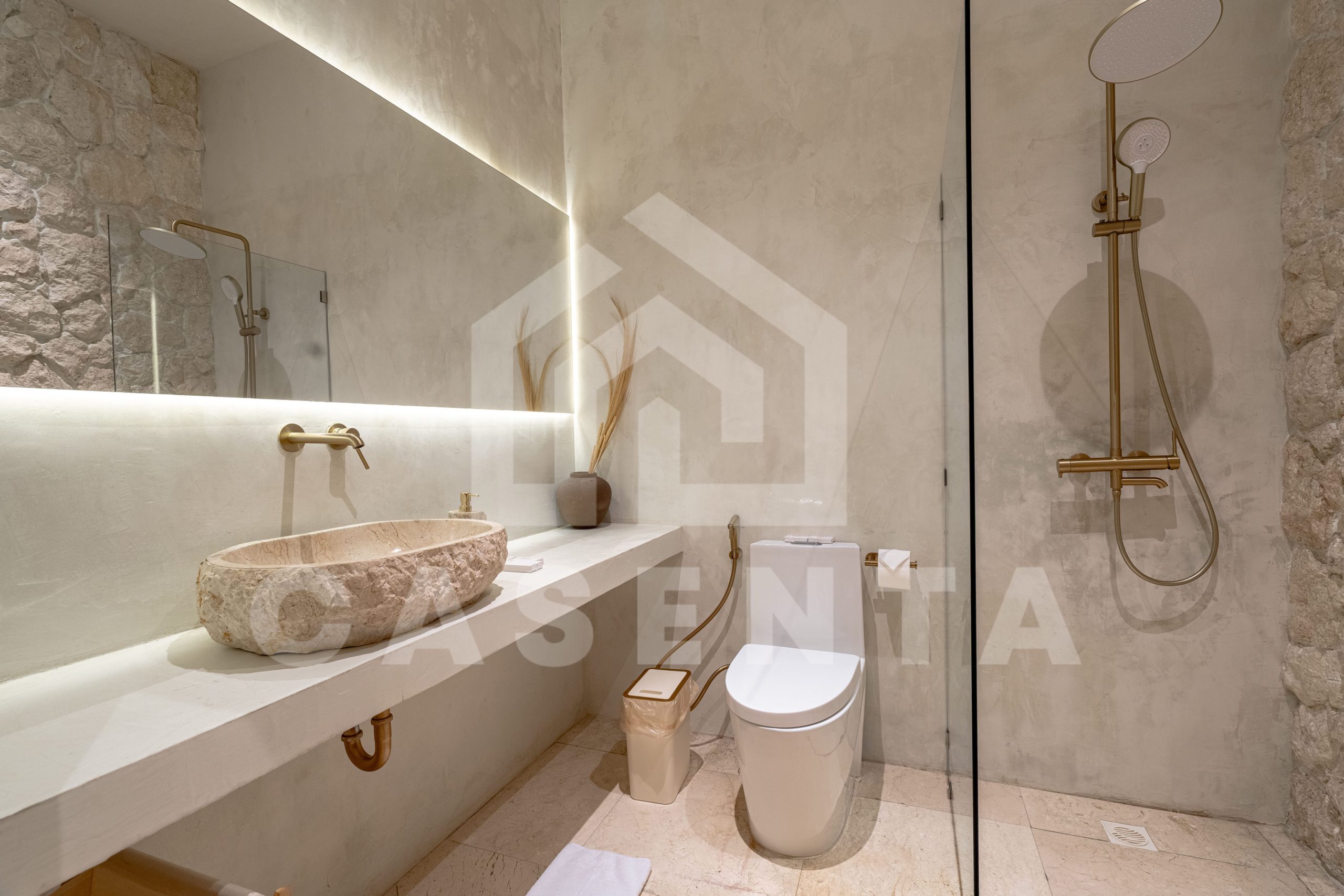 Modern bathroom in Sanur apartment with stone sink and walk-in shower