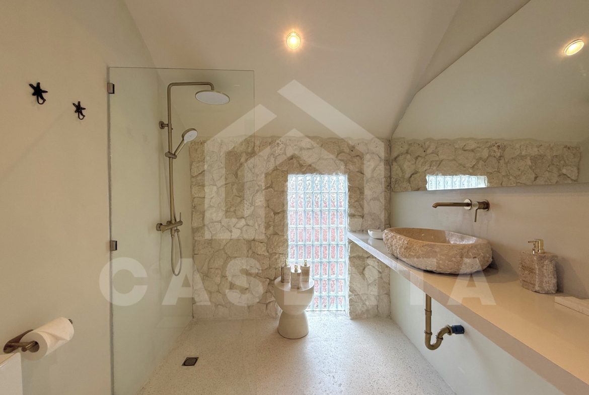 Contemporary bathroom with stone wall finish in sanur villa