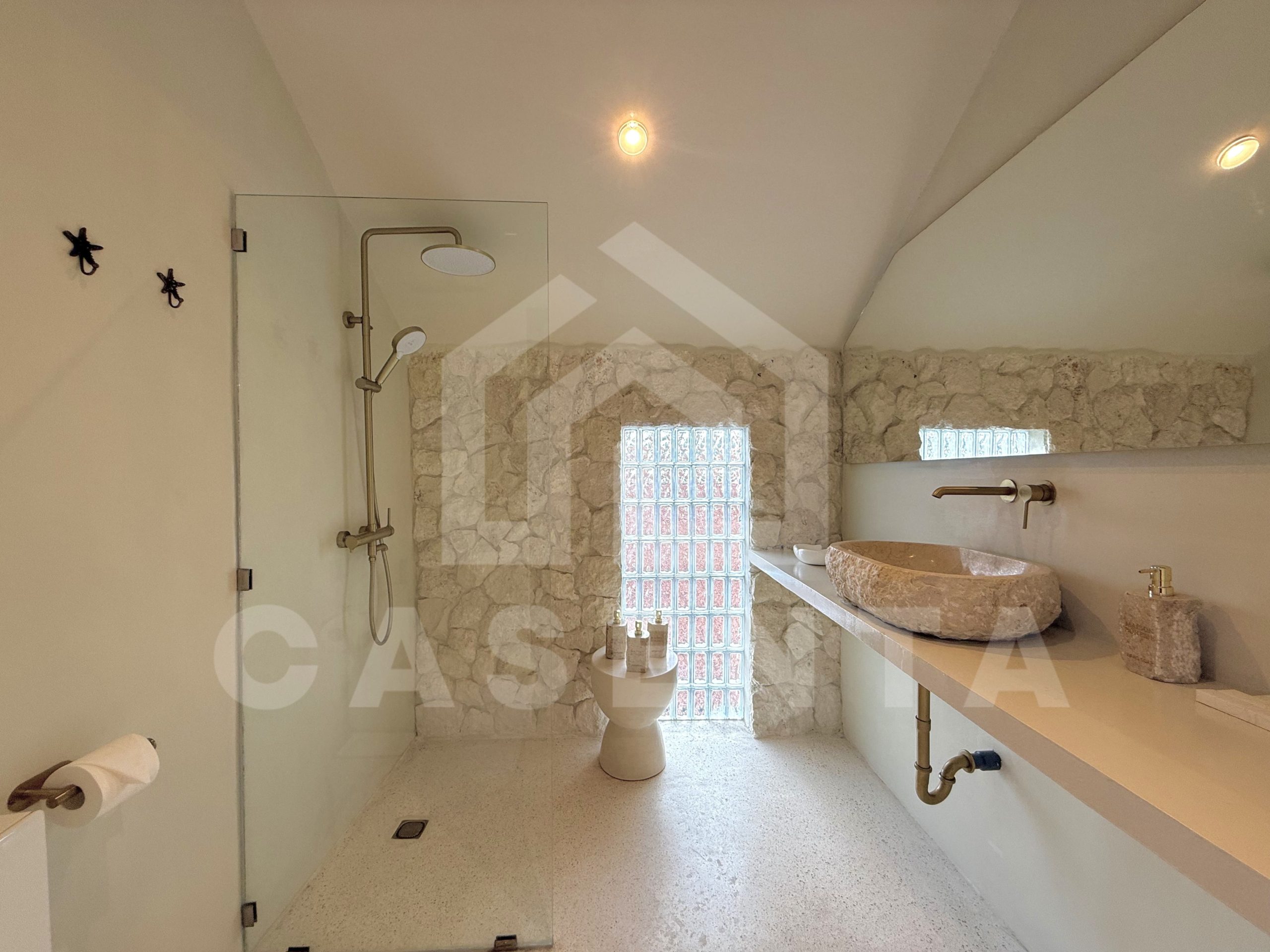 Contemporary bathroom with stone wall finish in sanur villa