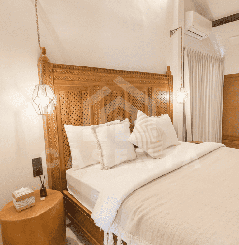 Bright bedroom with carved wood bed in Sanur Bali villa