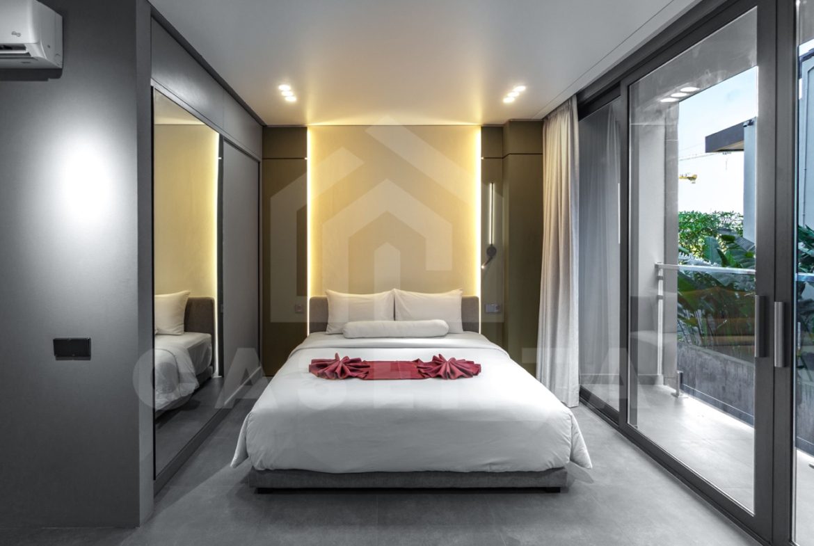 Minimalist bedroom in Canggu apartment with warm lighting and modern design