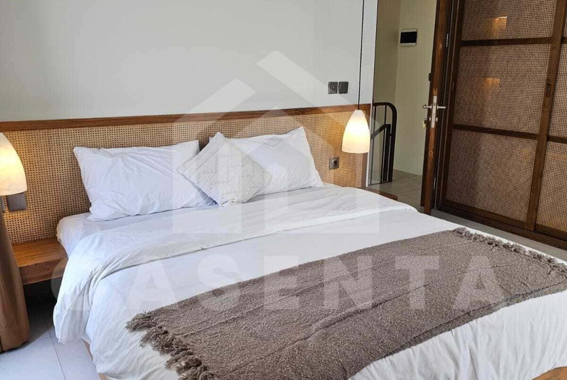 Ensuite bedroom with wooden furniture in cemagi villa