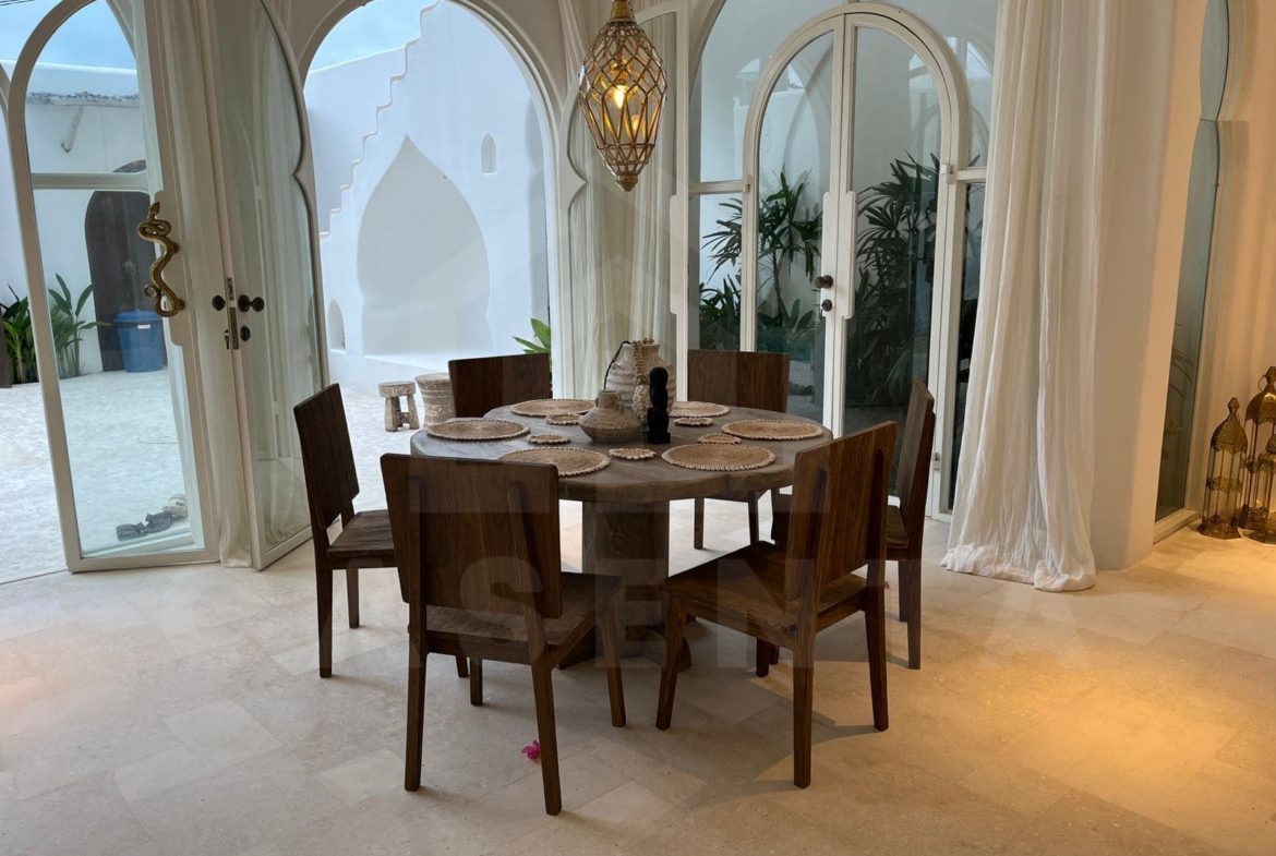 Dining area with arched glass doors in Mediterranean seseh villa
