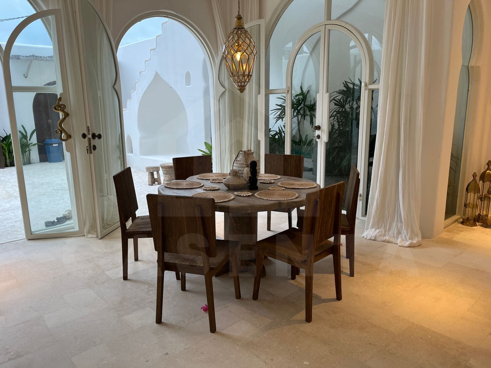 Dining area with arched glass doors in Mediterranean seseh villa