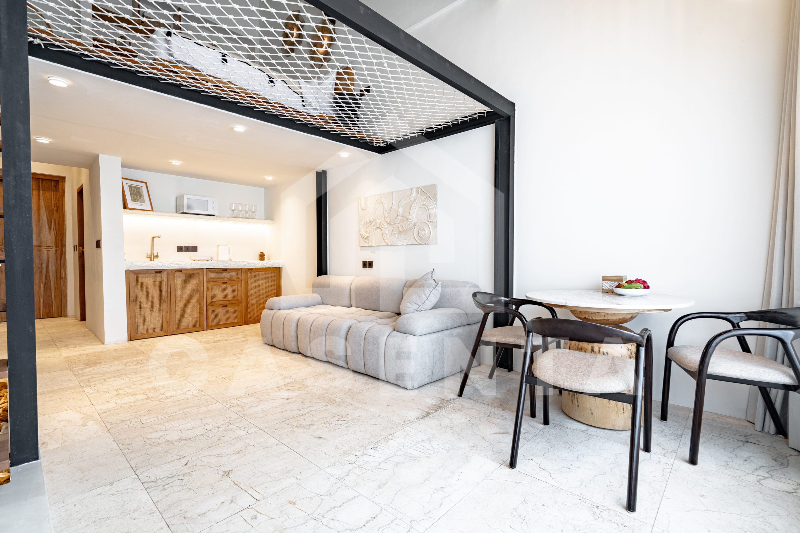 Living and dining area with mezzanine net hammock in Sanur apartment