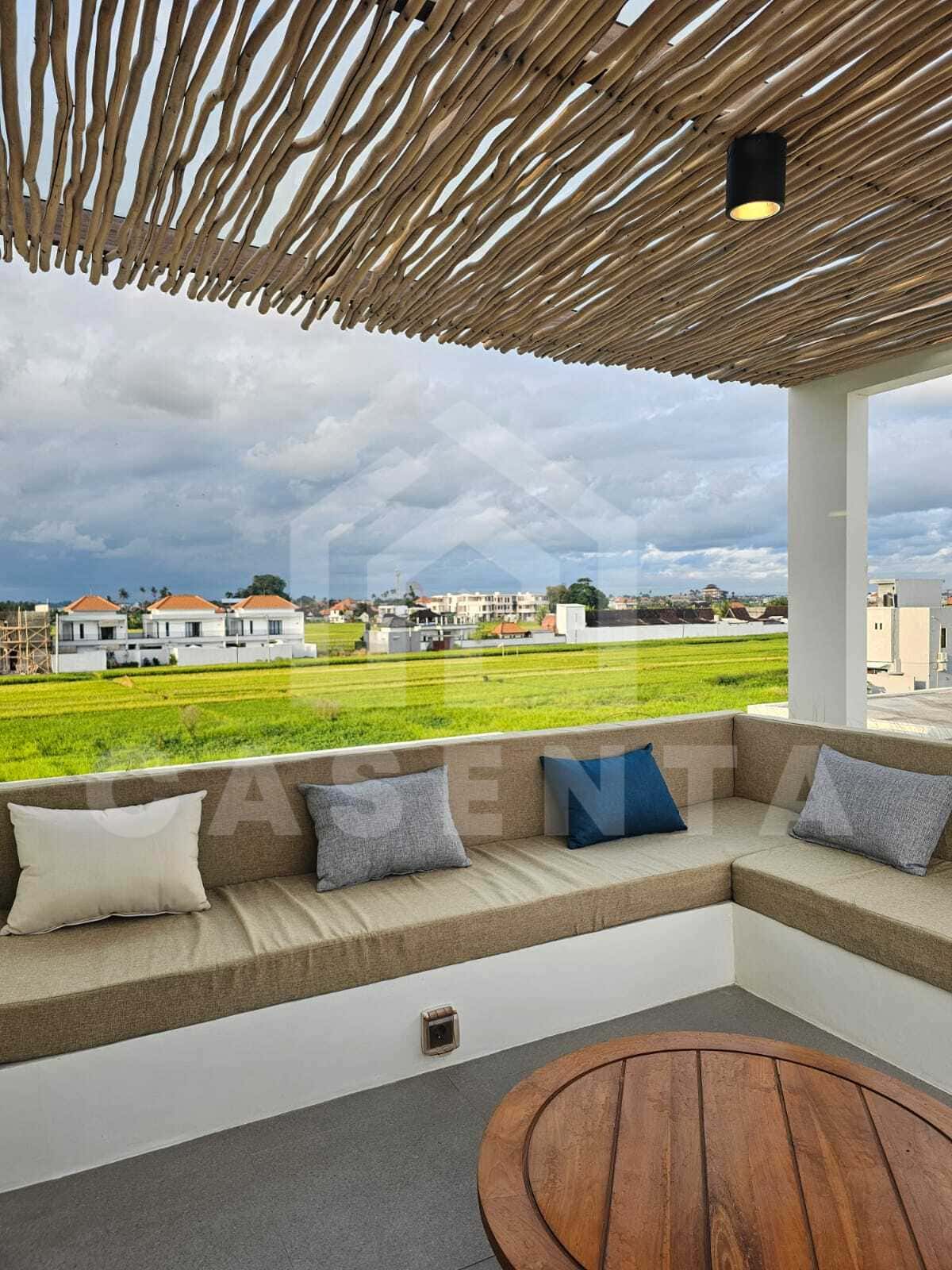 Rooftop lounge with rice field view at cemagi villa