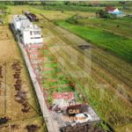 Cemagi land development plots with paved access road and rice field views
