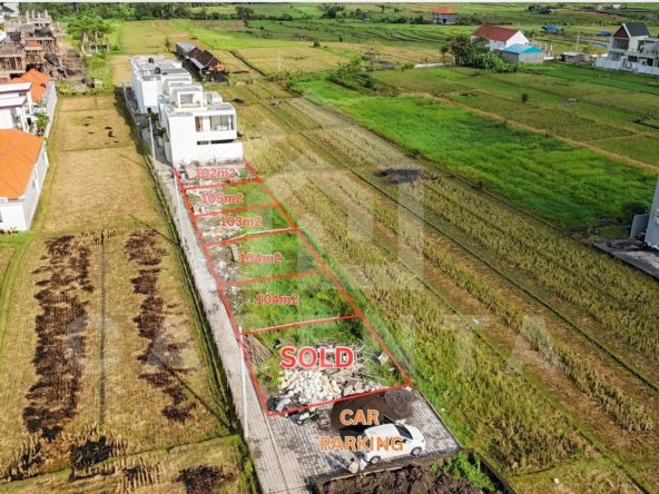 Cemagi land development plots with paved access road and rice field views