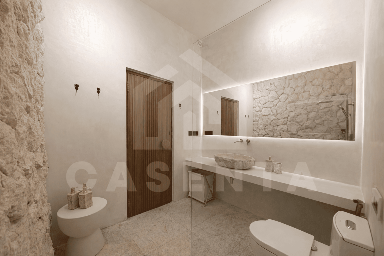 Modern bathroom in Sanur apartment with stone sink and walk-in shower