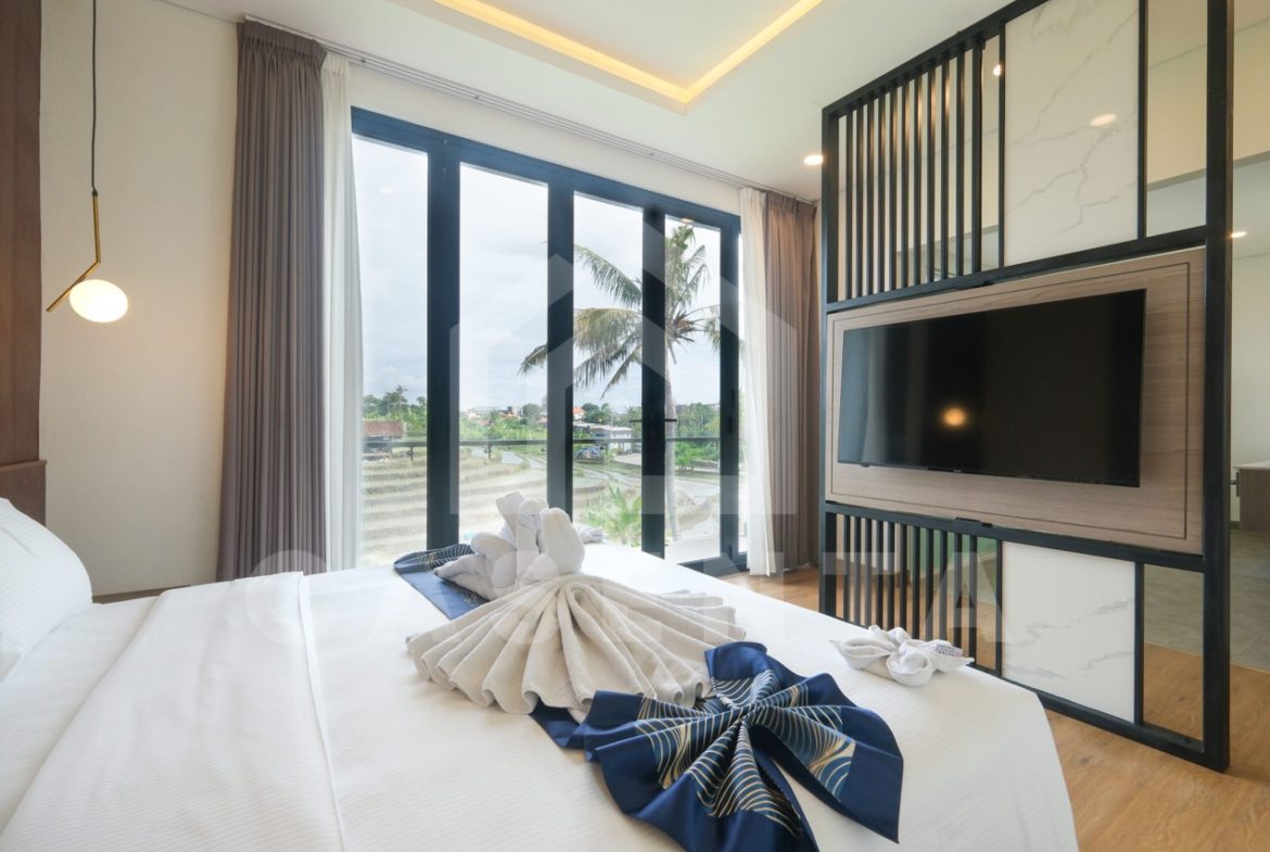 Bedroom with balcony and TV wall in Pererenan villa