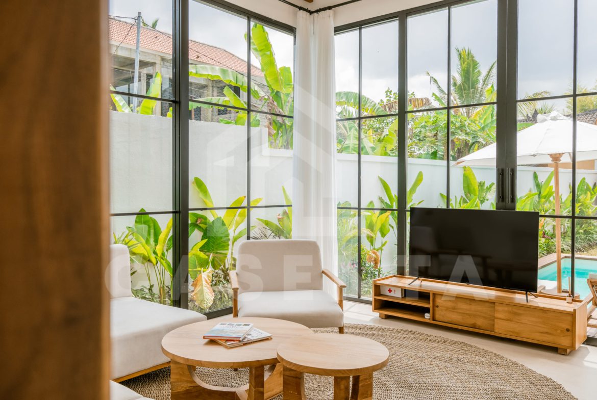Spacious living area with large windows overlooking garden in Ubud villa