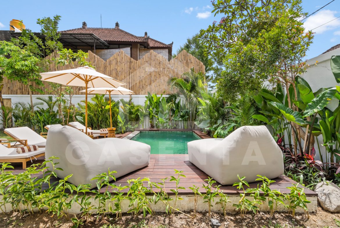 tropical garden and pool deck with lounge seating in Sayan villa